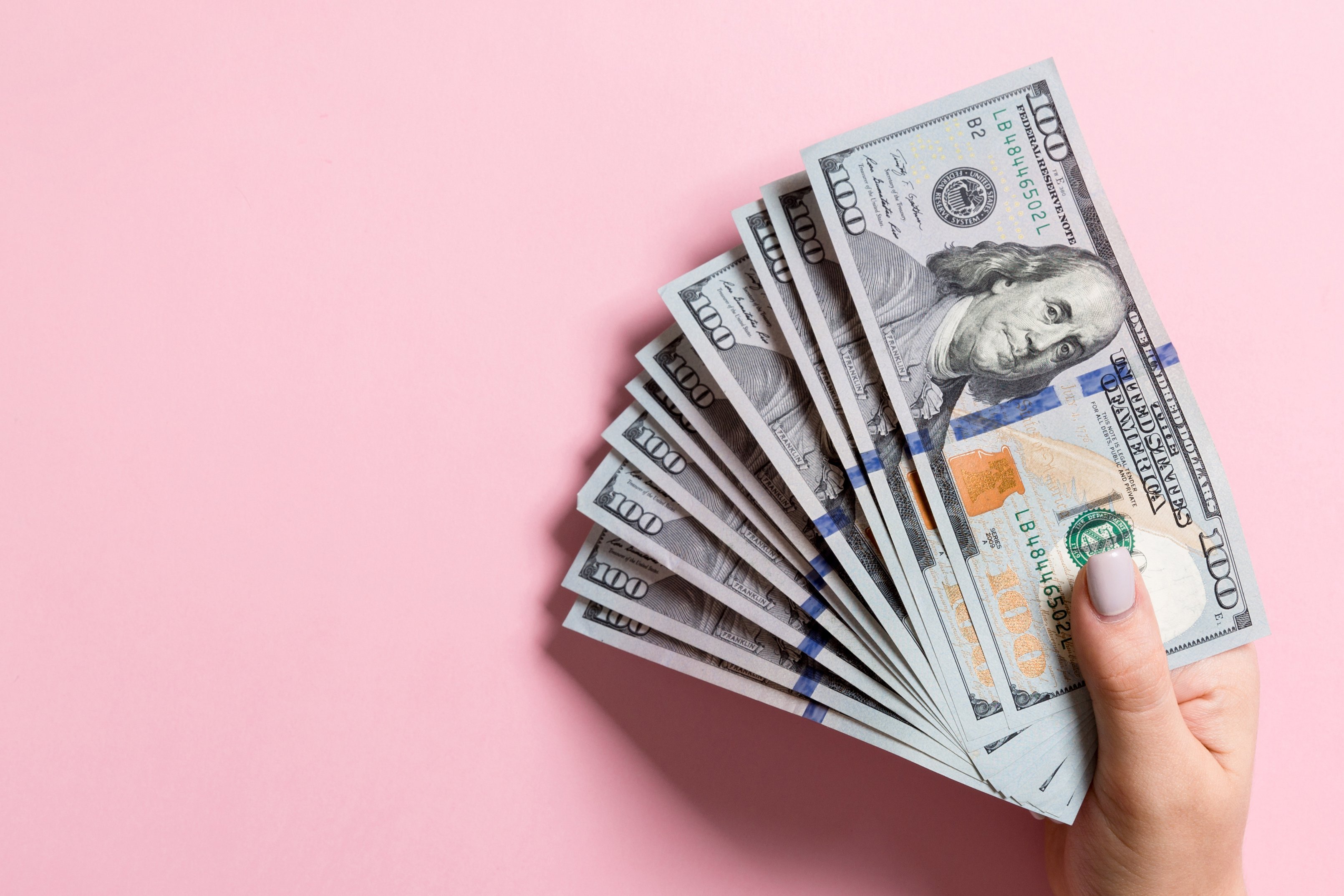 Dollar Bills on Pink Background