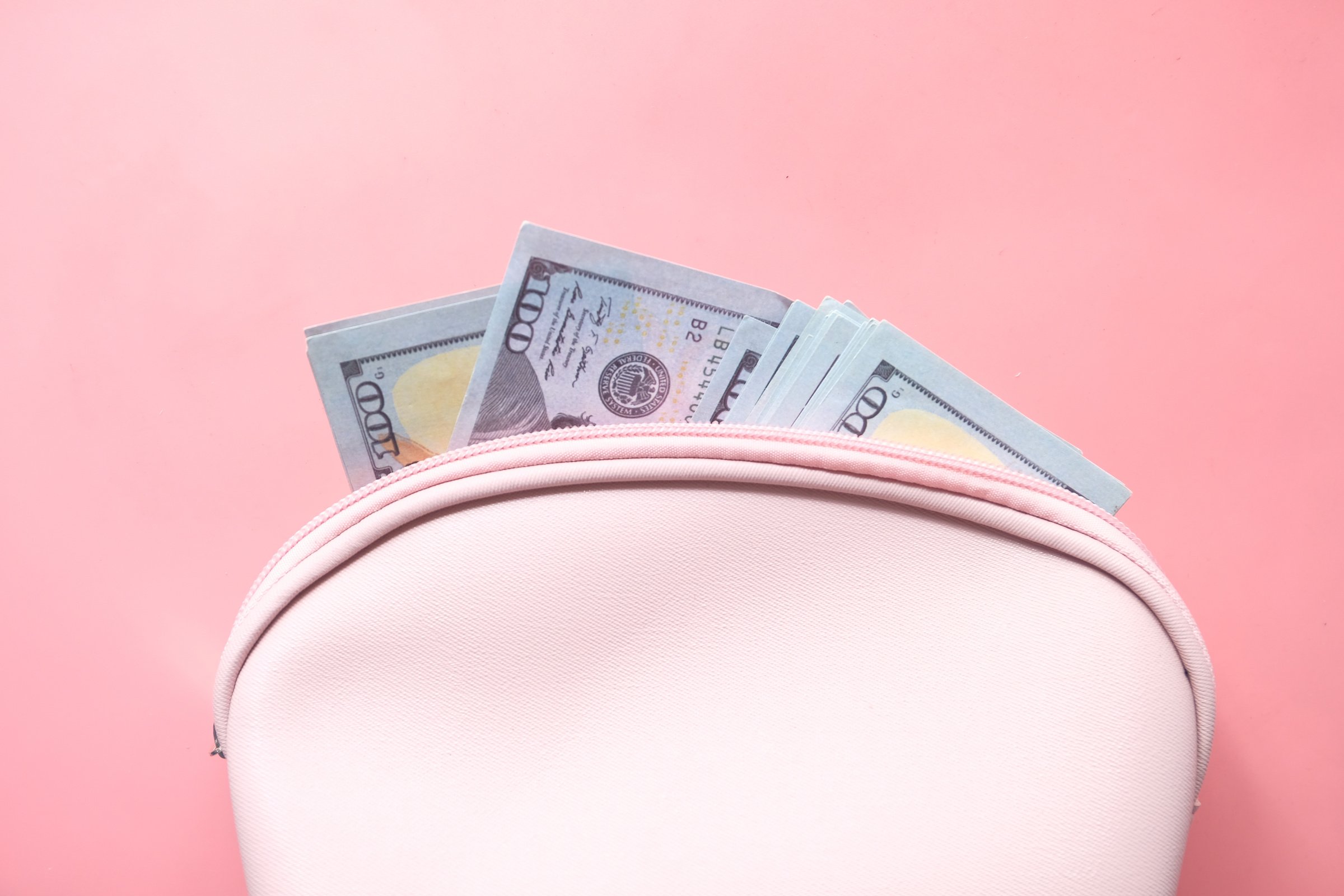 Close up of Cash in Wallet on Pink Background .